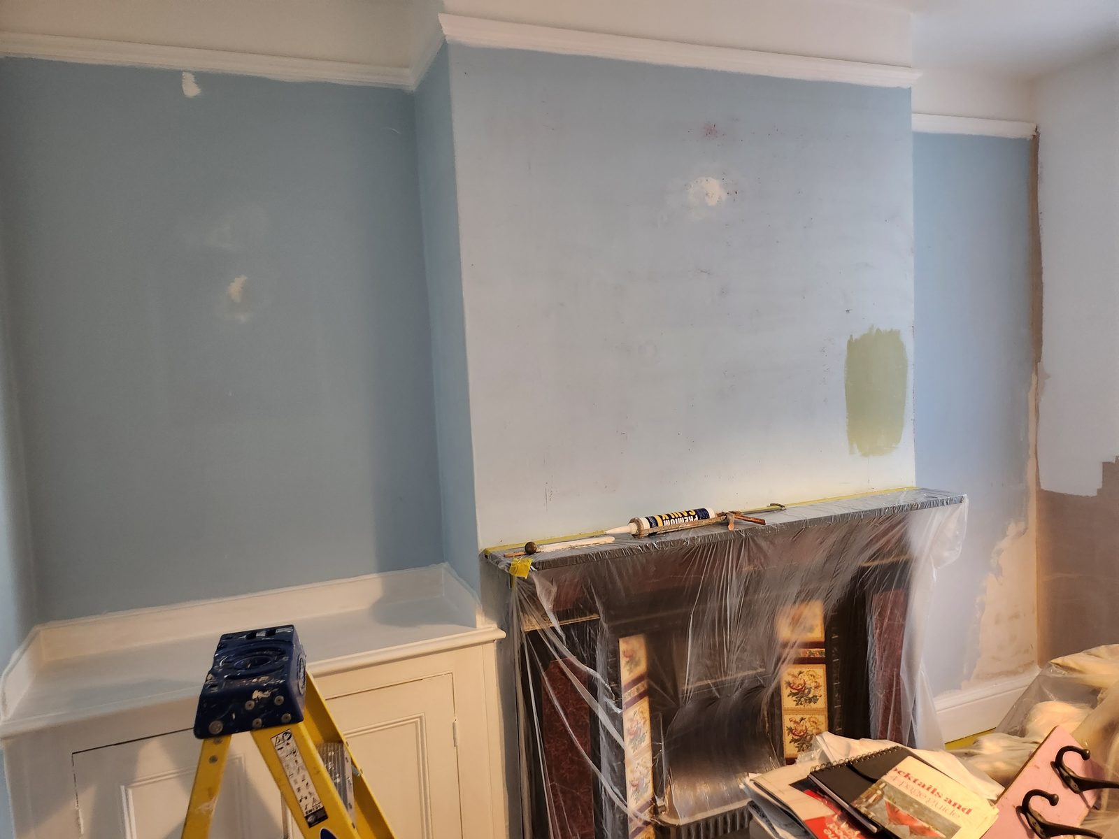 Period living room mid-decoration with fireplace and feature wall
